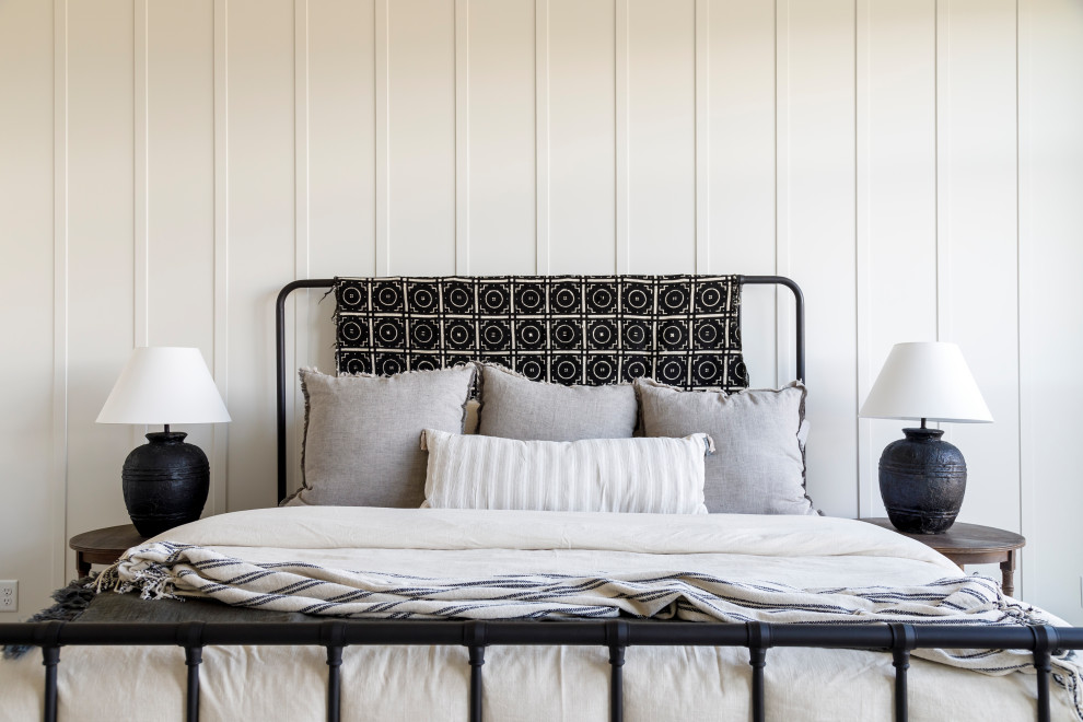 Mittelgroßes Landhaus Hauptschlafzimmer mit weißer Wandfarbe, braunem Holzboden, Kamin, verputzter Kaminumrandung, gewölbter Decke und Wandpaneelen in Boise