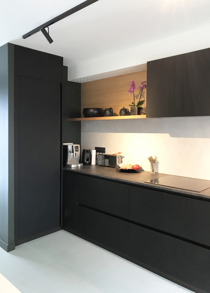 Foto på ett stort funkis svart linjärt kök med öppen planlösning, med en enkel diskho, luckor med profilerade fronter, svarta skåp, laminatbänkskiva, grått stänkskydd, klinkergolv i keramik och en köksö