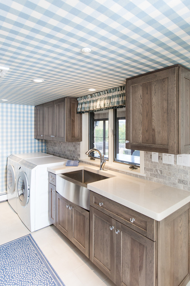 Design ideas for a mid-sized country galley dedicated laundry room in Other with shaker cabinets, solid surface benchtops, grey splashback, subway tile splashback, a farmhouse sink, ceramic floors, a side-by-side washer and dryer, beige benchtop and dark wood cabinets.