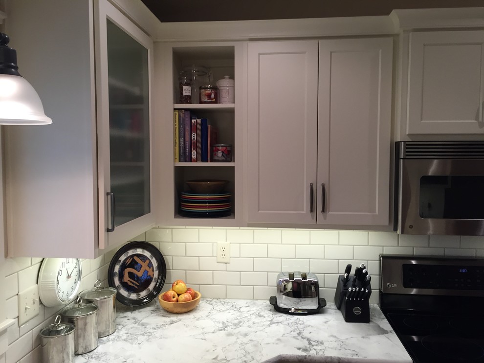 Eat-in kitchen - mid-sized transitional u-shaped medium tone wood floor eat-in kitchen idea with an integrated sink, shaker cabinets, white cabinets, laminate countertops, white backsplash, subway tile backsplash, stainless steel appliances and a peninsula