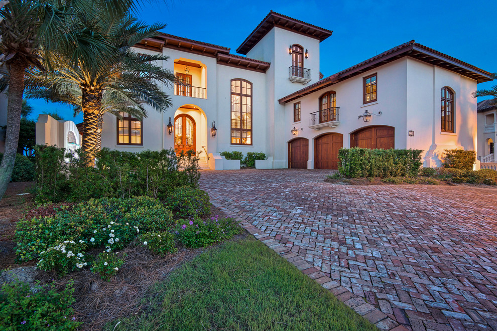 This is an example of a large mediterranean backyard partial sun driveway in Miami with a water feature and brick pavers.