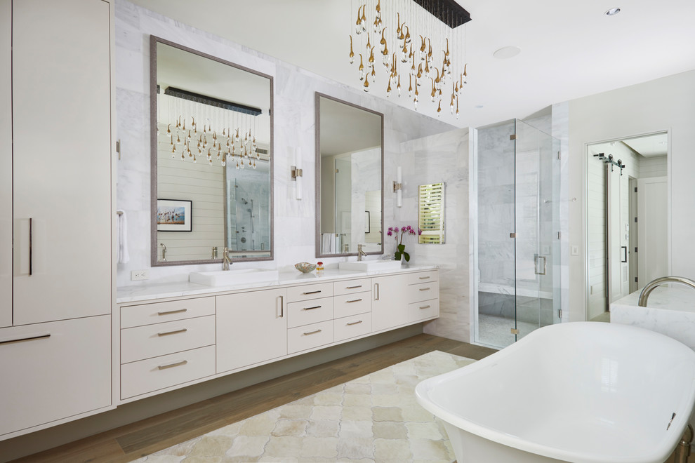 Design ideas for a country master bathroom in Austin with flat-panel cabinets, beige cabinets, gray tile, beige floor, a hinged shower door and white benchtops.