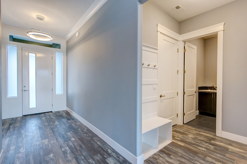 Design ideas for a mid-sized transitional entry hall in Seattle with grey walls, medium hardwood floors, a single front door and a white front door.