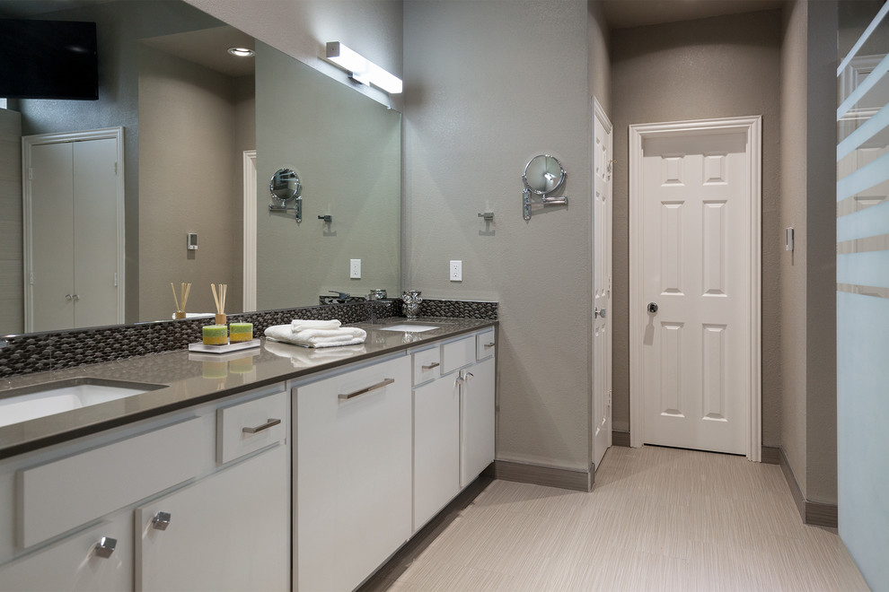 This is an example of a mid-sized contemporary master bathroom in Dallas with an undermount sink, flat-panel cabinets, an open shower, a one-piece toilet, grey walls, ceramic floors, white cabinets, black tile, gray tile, mosaic tile and solid surface benchtops.