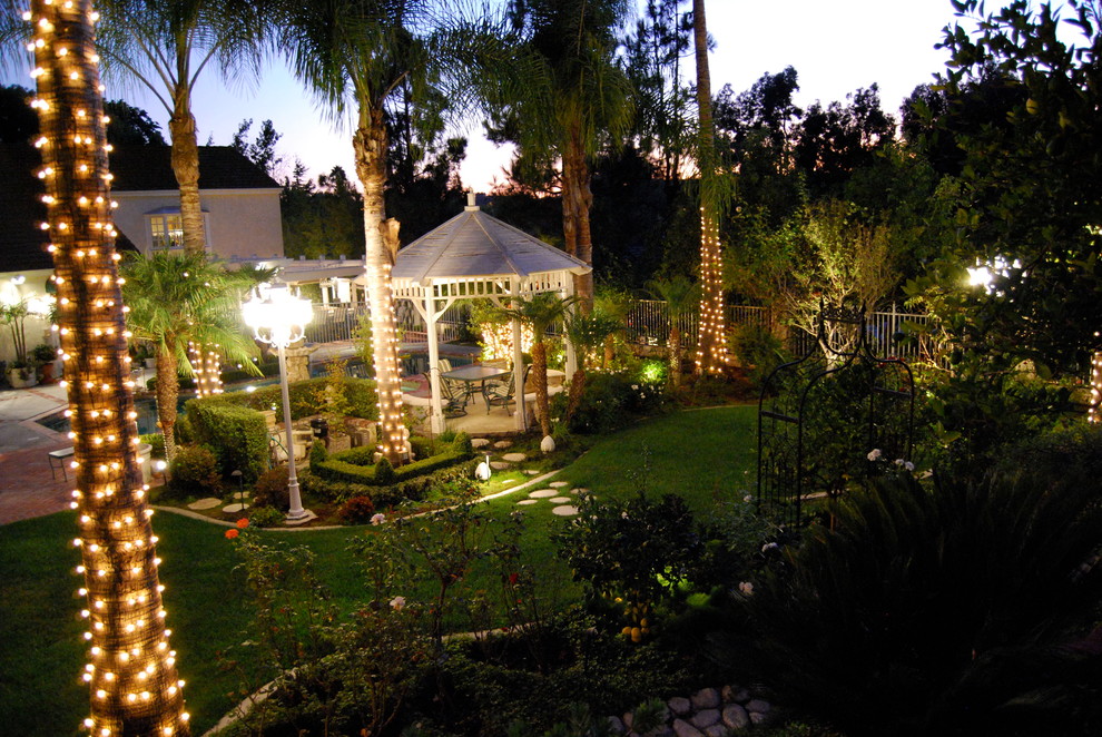 Photo of a huge transitional shade backyard brick landscaping in Orange County.