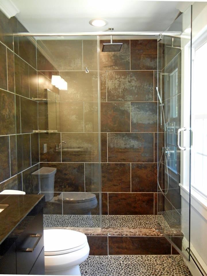 Inspiration for a mid-sized modern 3/4 bathroom in New York with an undermount sink, flat-panel cabinets, dark wood cabinets, granite benchtops, brown tile, porcelain tile, brown walls and pebble tile floors.