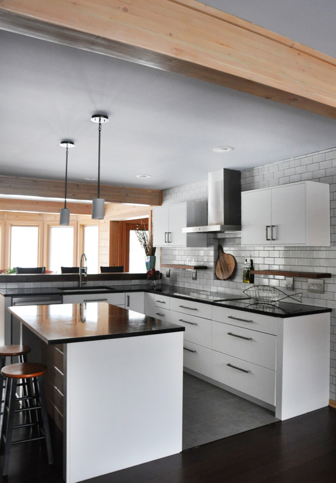 Inspiration for a mid-sized transitional l-shaped dark wood floor eat-in kitchen remodel in Grand Rapids with an undermount sink, flat-panel cabinets, white cabinets, soapstone countertops, white backsplash, subway tile backsplash, stainless steel appliances and an island