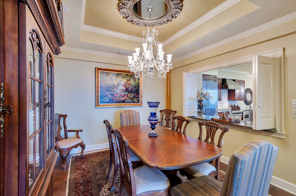 Design ideas for a traditional separate dining room in Miami with beige walls and dark hardwood floors.