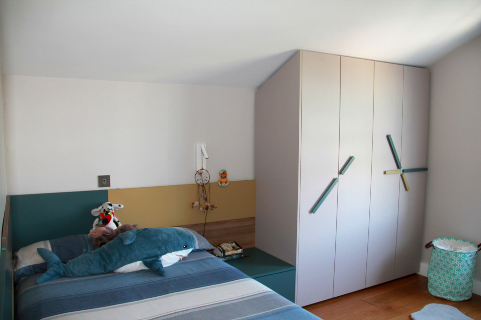 Cette image montre une chambre d'enfant minimaliste de taille moyenne avec un mur beige, un sol en bois brun et du lambris.