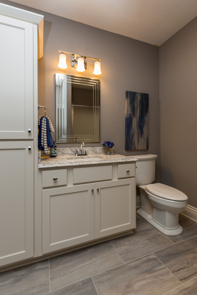 Inspiration for a transitional 3/4 gray tile porcelain tile bathroom remodel with an undermount sink, shaker cabinets, white cabinets, quartz countertops, a two-piece toilet and gray walls