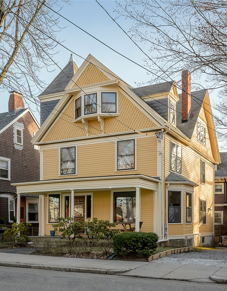 This is an example of a traditional yellow exterior in Boston with wood siding.