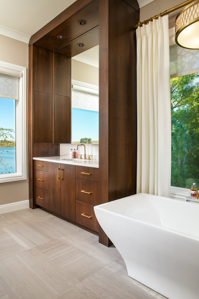 Design ideas for a large contemporary master bathroom in Omaha with flat-panel cabinets, dark wood cabinets, a freestanding tub, a corner shower, white tile, marble, brown walls, porcelain floors, an undermount sink, marble benchtops, brown floor and a hinged shower door.