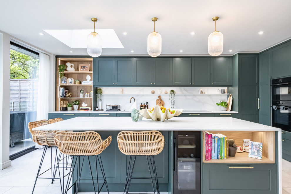 Klassische Küche mit Schrankfronten im Shaker-Stil, grünen Schränken, Quarzit-Arbeitsplatte und Kücheninsel in London