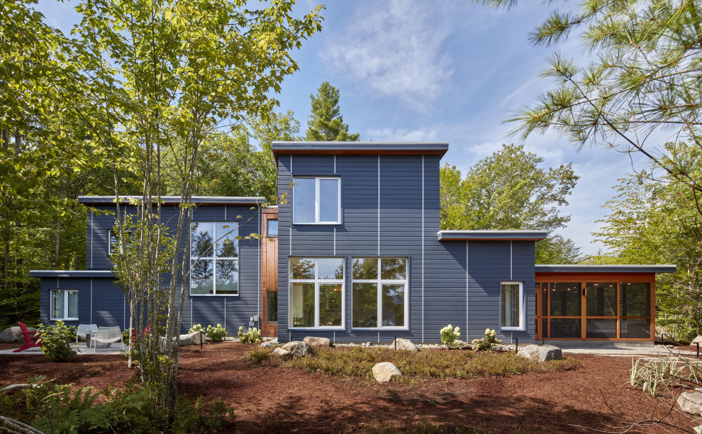 Свежая идея для дизайна: двухэтажный, синий частный загородный дом среднего размера в стиле модернизм с плоской крышей - отличное фото интерьера