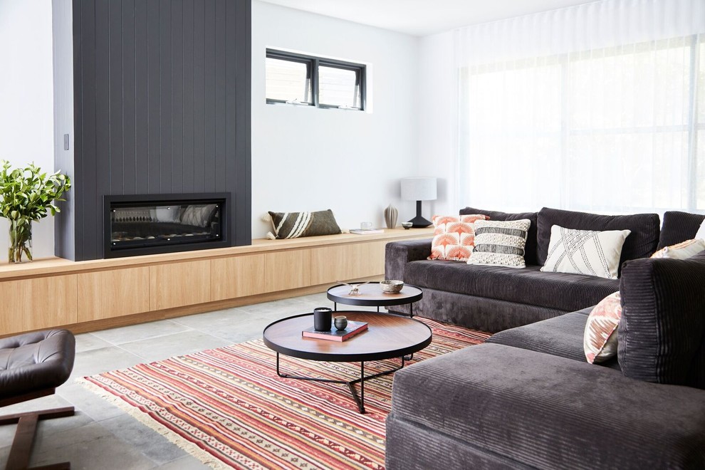 Contemporary living room in Sydney with white walls, ceramic floors, a standard fireplace, a wood fireplace surround and grey floor.