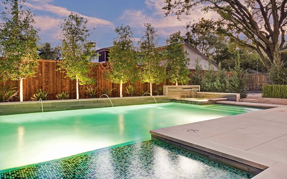 Photo of a modern pool in Dallas with concrete pavers.