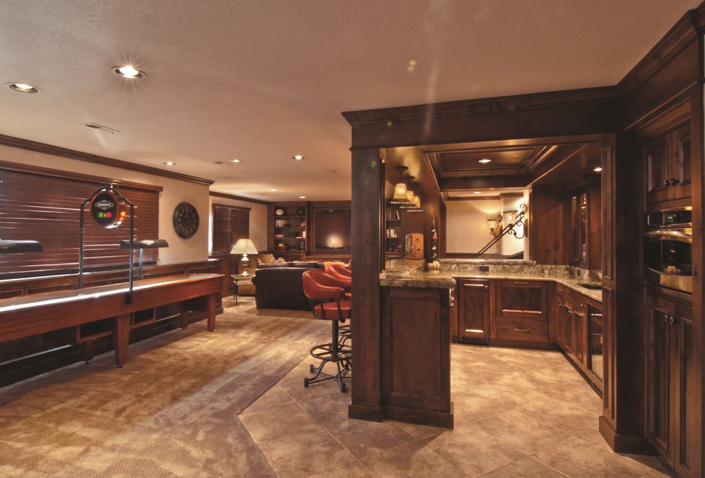 This is an example of an expansive traditional wet bar in Wichita with an undermount sink, raised-panel cabinets, dark wood cabinets, granite benchtops, porcelain floors, beige floor and stone slab splashback.