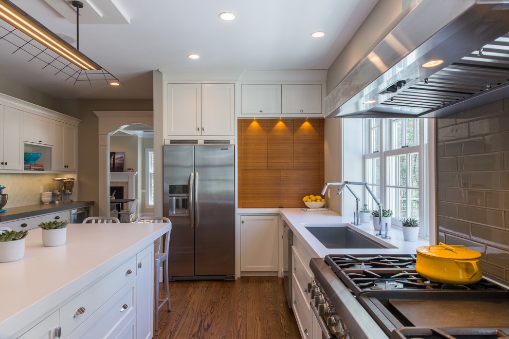 Kitchen - transitional kitchen idea in Boston with an undermount sink, shaker cabinets, white cabinets, quartz countertops, gray backsplash, subway tile backsplash and stainless steel appliances