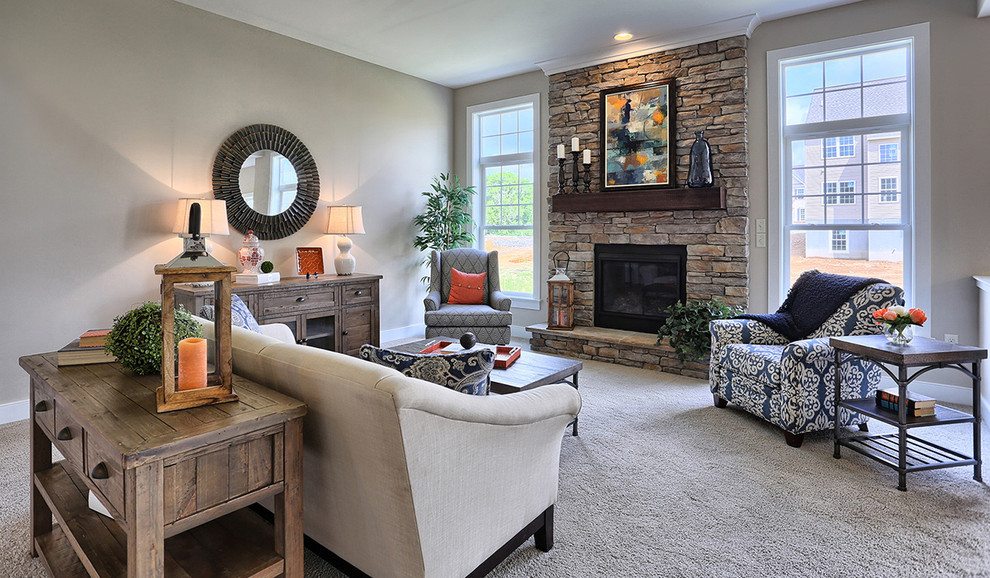 Photo of a mid-sized arts and crafts open concept family room in Other with carpet, a standard fireplace, a stone fireplace surround, beige walls, no tv and beige floor.