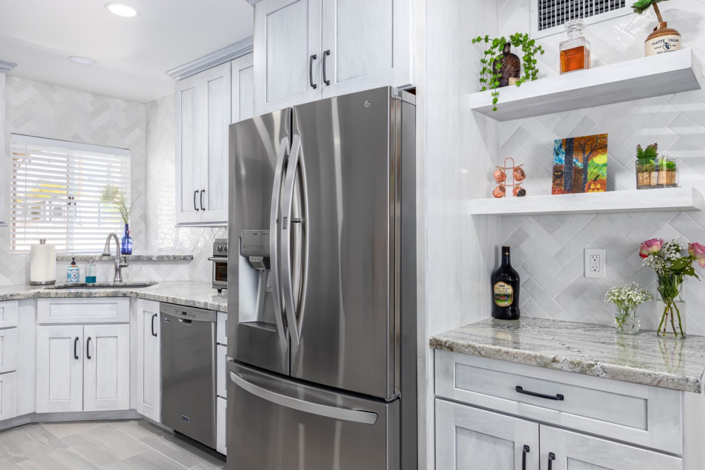 Inspiration for a transitional l-shaped kitchen remodel in Phoenix with a single-bowl sink, shaker cabinets, white cabinets, granite countertops, white backsplash and stainless steel appliances