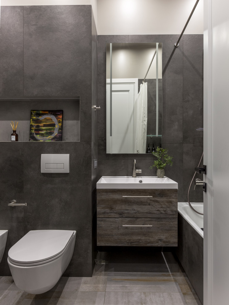 Inspiration for a mid-sized contemporary kids bathroom in Moscow with furniture-like cabinets, distressed cabinets, an alcove tub, a wall-mount toilet, gray tile, ceramic tile, grey walls, ceramic floors, an integrated sink, grey floor, a single vanity and a floating vanity.