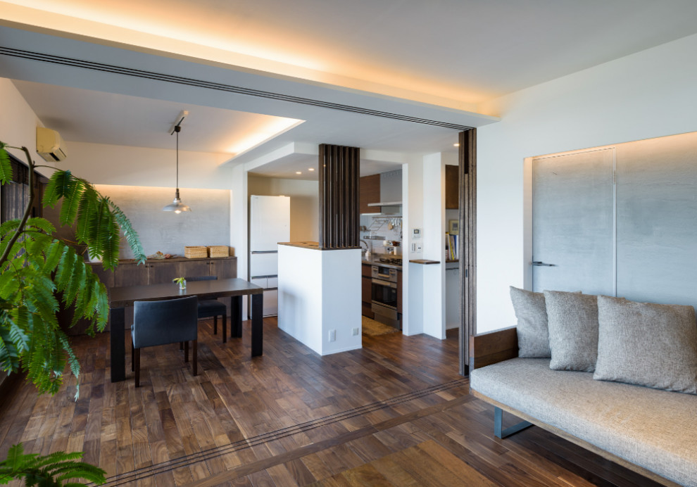 Idée de décoration pour une salle à manger ouverte sur le salon asiatique avec un mur gris, parquet foncé et un sol marron.