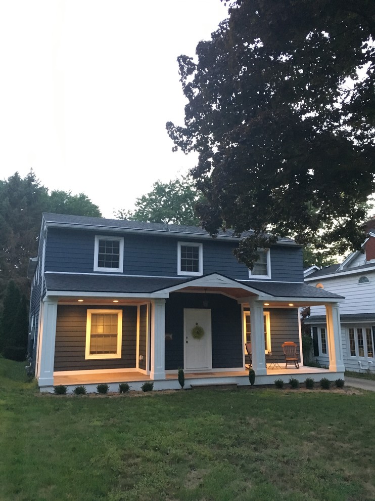 This is an example of a mid-sized transitional two-storey blue house exterior in Detroit with wood siding, a gable roof and a shingle roof.