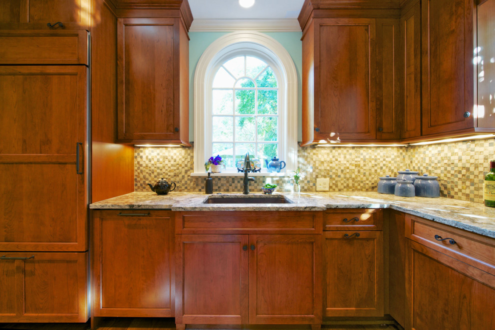 Enclosed kitchen - mid-sized transitional u-shaped medium tone wood floor enclosed kitchen idea with an undermount sink, recessed-panel cabinets, medium tone wood cabinets, granite countertops, multicolored backsplash, mosaic tile backsplash, paneled appliances and a peninsula