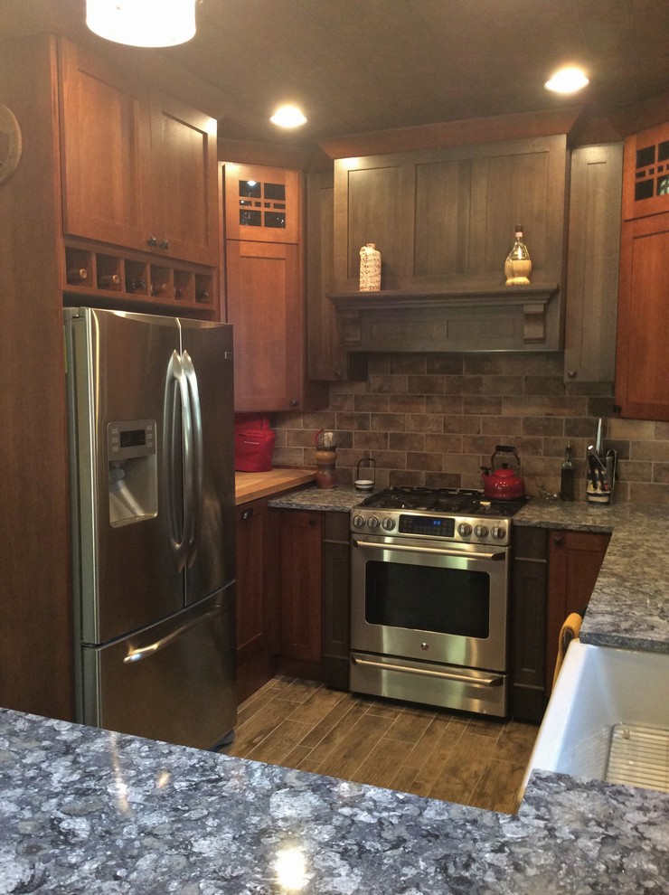 Example of a mountain style u-shaped porcelain tile eat-in kitchen design in Chicago with shaker cabinets, porcelain backsplash, stainless steel appliances, a peninsula, dark wood cabinets, quartz countertops and brown backsplash