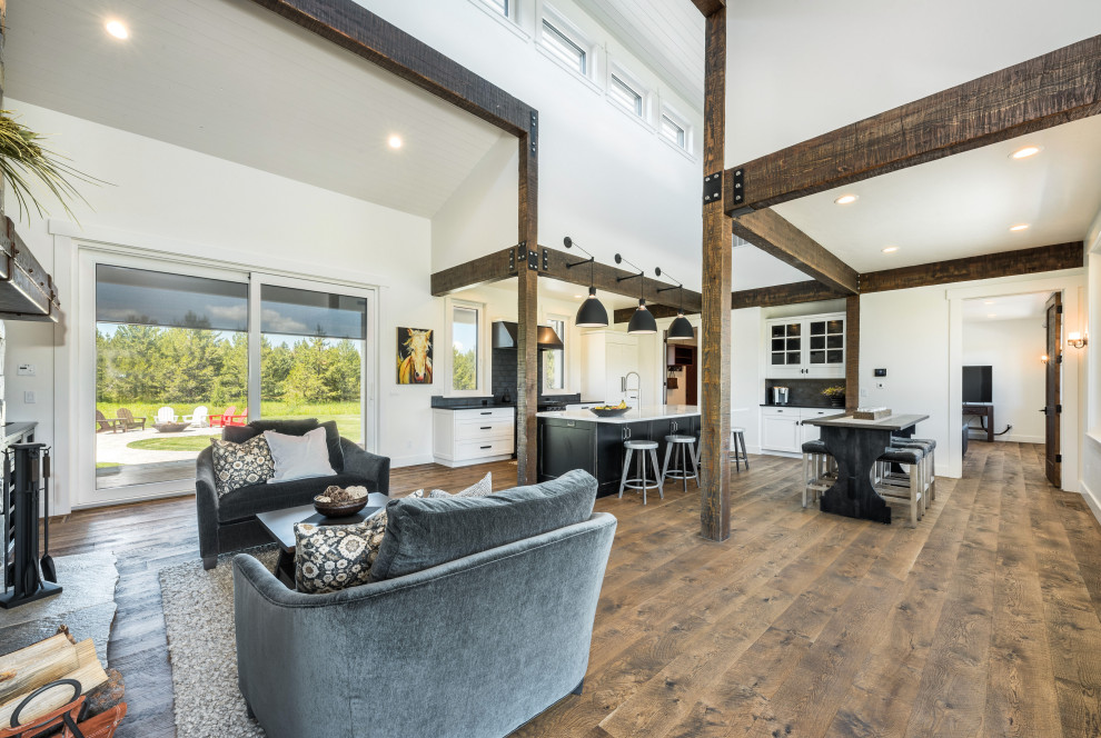 This is an example of a country open concept living room in Boise with white walls and medium hardwood floors.