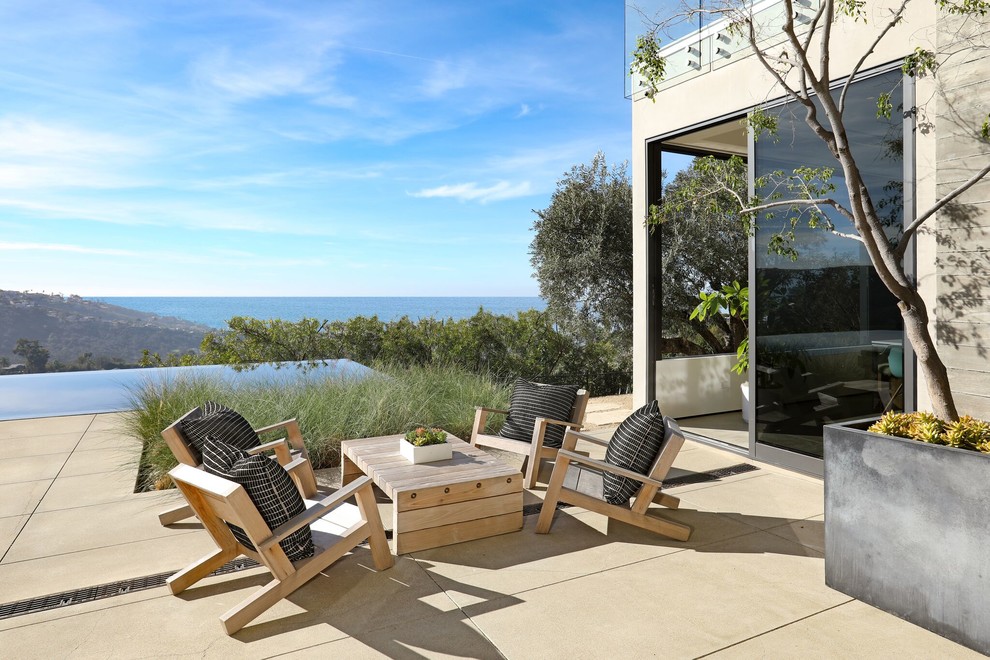 Example of a trendy backyard concrete paver patio design in Orange County with no cover