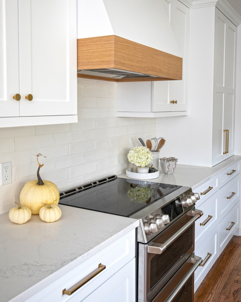 Mid-sized transitional galley medium tone wood floor and brown floor eat-in kitchen photo in Dallas with a farmhouse sink, shaker cabinets, white cabinets, quartz countertops, white backsplash, subway tile backsplash, stainless steel appliances, no island and white countertops