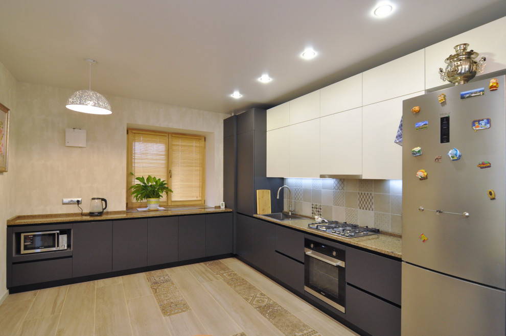 This is an example of a medium sized contemporary grey and white l-shaped kitchen/diner in Other with a built-in sink, flat-panel cabinets, grey cabinets, granite worktops, beige splashback, ceramic splashback, black appliances, ceramic flooring, no island, beige floors, brown worktops and a coffered ceiling.