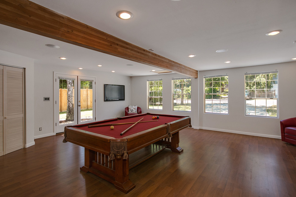 This is an example of a large contemporary enclosed family room in Seattle with a game room, grey walls, a wall-mounted tv and dark hardwood floors.