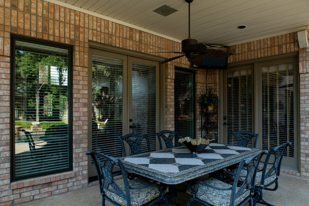 This is an example of a mid-sized backyard patio in Dallas with an outdoor kitchen, gravel and a roof extension.