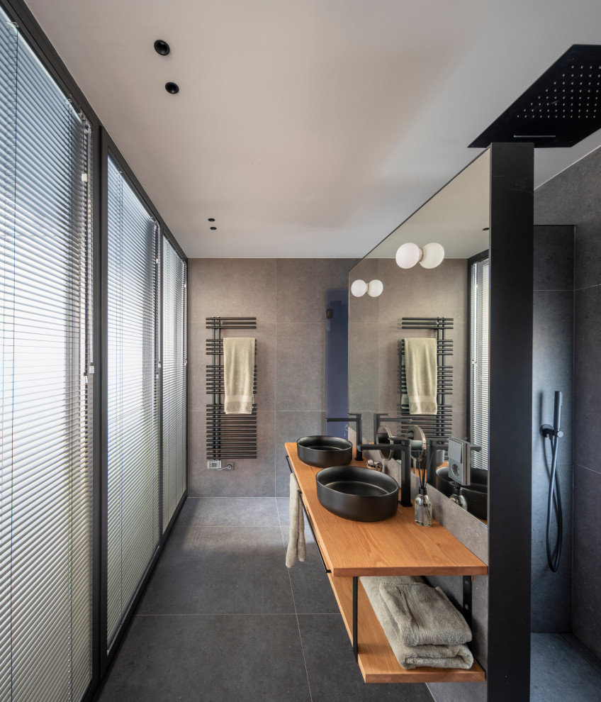 Design ideas for a contemporary bathroom in Other with open cabinets, medium wood cabinets, a built-in shower, grey tiles, a vessel sink, wooden worktops, grey floors, an open shower, brown worktops, double sinks and a floating vanity unit.