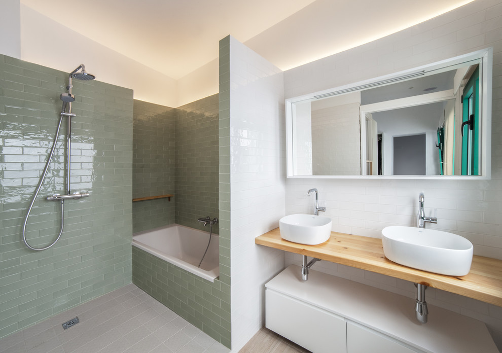 This is an example of a contemporary master bathroom in Other with open cabinets, light wood cabinets, an alcove tub, green tile, white tile, a vessel sink, wood benchtops, an open shower, an open shower, grey floor and beige benchtops.