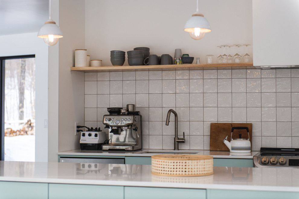 モントリオールにある北欧スタイルのおしゃれなアイランドキッチン (御影石カウンター、白いキッチンパネル、コンクリートの床、白いキッチンカウンター) の写真