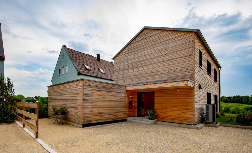 This is an example of a scandinavian two floor detached house in Munich with wood cladding, a pitched roof, a tiled roof, a grey roof and shiplap cladding.