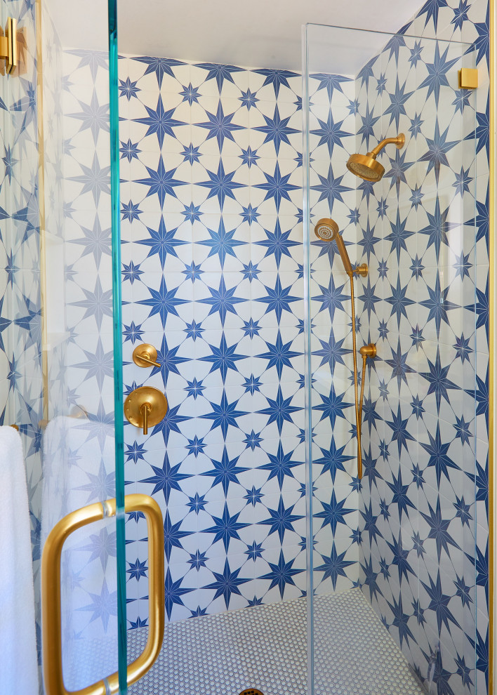 Photo of a mid-sized beach style bathroom in San Francisco with recessed-panel cabinets, blue cabinets, an alcove shower, a one-piece toilet, blue tile, white tile, ceramic tile, white walls, mosaic tile floors, an undermount sink, engineered quartz benchtops, white floor, a hinged shower door and white benchtops.