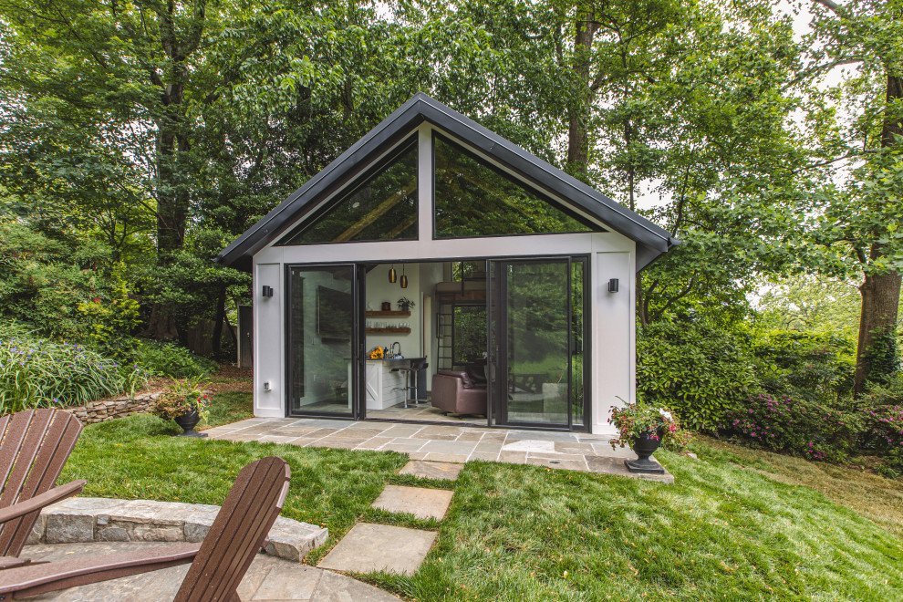 Пример оригинального дизайна: маленький, двухэтажный, серый мини дом в стиле модернизм с облицовкой из цементной штукатурки, двускатной крышей, металлической крышей и черной крышей для на участке и в саду