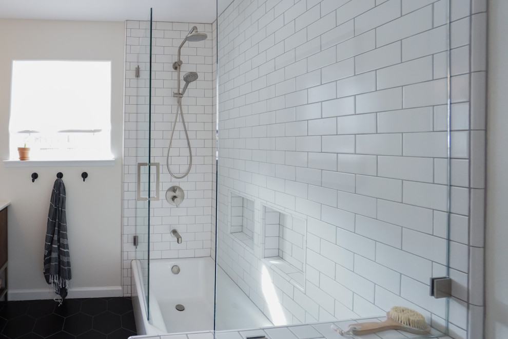 Photo of a mid-sized midcentury master bathroom in San Francisco with medium wood cabinets, a one-piece toilet, subway tile, white walls, ceramic floors, an undermount sink, marble benchtops, black floor, a hinged shower door, flat-panel cabinets, an alcove tub, a shower/bathtub combo, white tile, white benchtops, a double vanity and a built-in vanity.