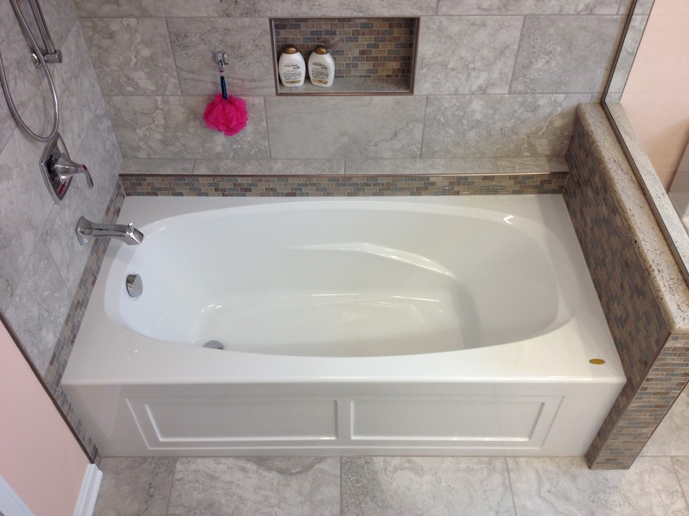Alcove bathtub - mid-sized transitional gray tile and porcelain tile porcelain tile alcove bathtub idea with an undermount sink, raised-panel cabinets, white cabinets, granite countertops and orange walls