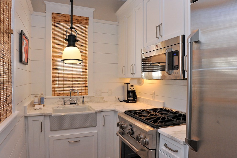 Small beach style l-shaped separate kitchen in Miami with a farmhouse sink, shaker cabinets, white cabinets, marble benchtops, stainless steel appliances, no island and shiplap splashback.