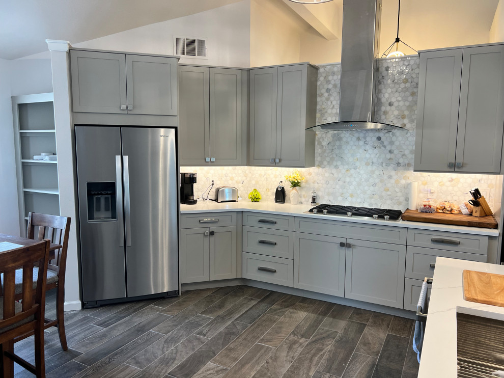 Large transitional u-shaped porcelain tile and brown floor eat-in kitchen photo in Austin with an undermount sink, shaker cabinets, gray cabinets, quartz countertops, white backsplash, marble backsplash, stainless steel appliances, an island and white countertops