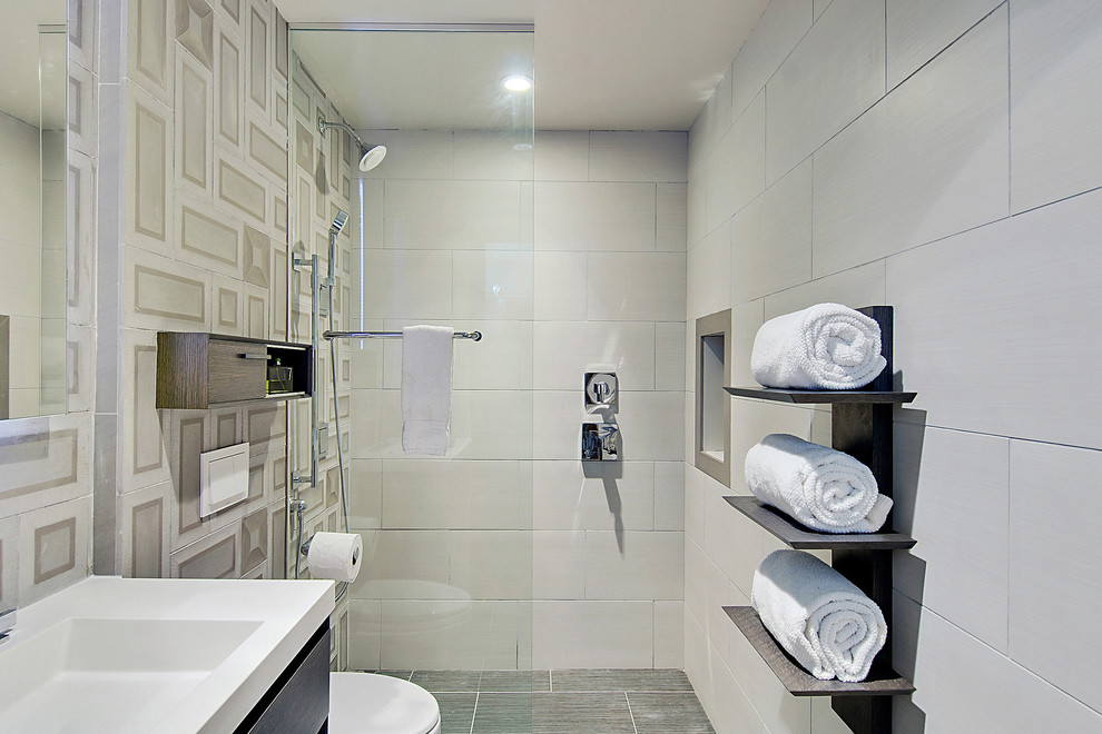 Inspiration for a small contemporary bathroom in New Orleans with a wall-mount sink, a curbless shower, a wall-mount toilet, stone tile and porcelain floors.