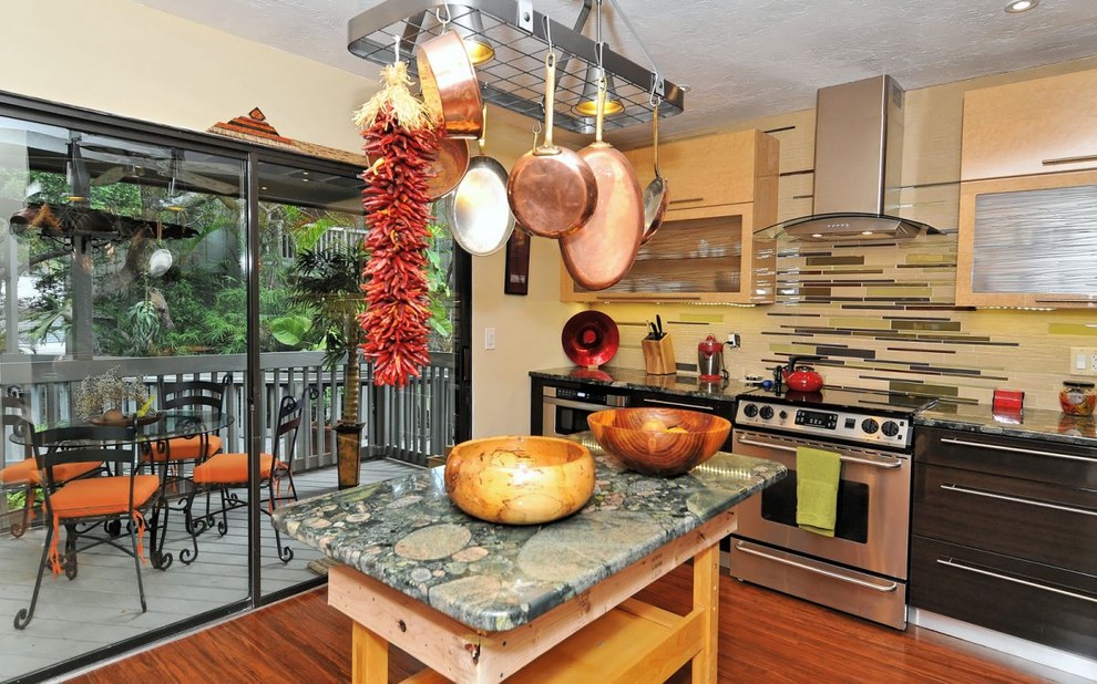 Small eclectic u-shaped eat-in kitchen in Tampa with an undermount sink, flat-panel cabinets, light wood cabinets, granite benchtops, glass tile splashback, stainless steel appliances, bamboo floors, multi-coloured splashback, with island and brown floor.