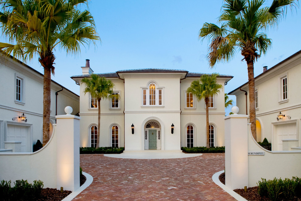 This is an example of a large traditional two-storey stucco white house exterior in Jacksonville with a hip roof.