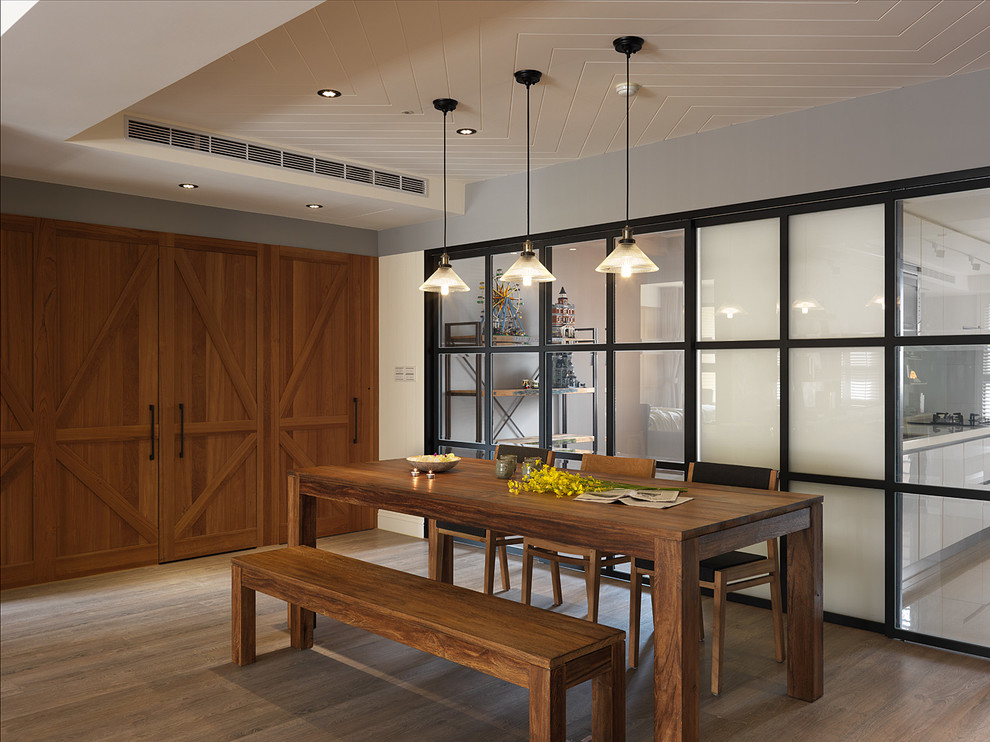 This is an example of a contemporary dining room in Singapore with grey walls and light hardwood floors.