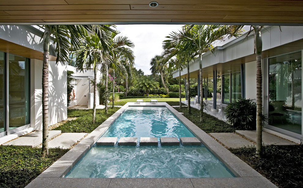 Inspiration for a modern courtyard rectangular pool in Miami with concrete slab.